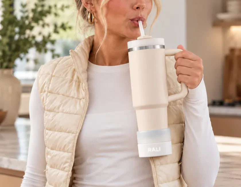 Woman sipping from a Stanley Quencher 30 oz on a RALI Base